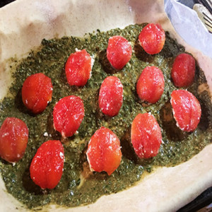 torta salata senza pastasfoglia con pomodorini ripieni di tofu o formaggio in un letto di pesto alla genovese